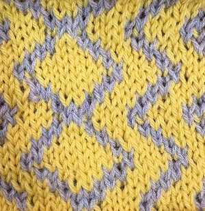 Close-up of yellow and lilac knitted fabric with a chevron pattern